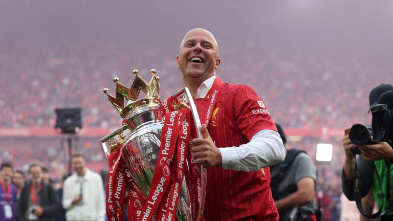 A picture of Liverpool manager Arne Slot holding the Premier League trophy.