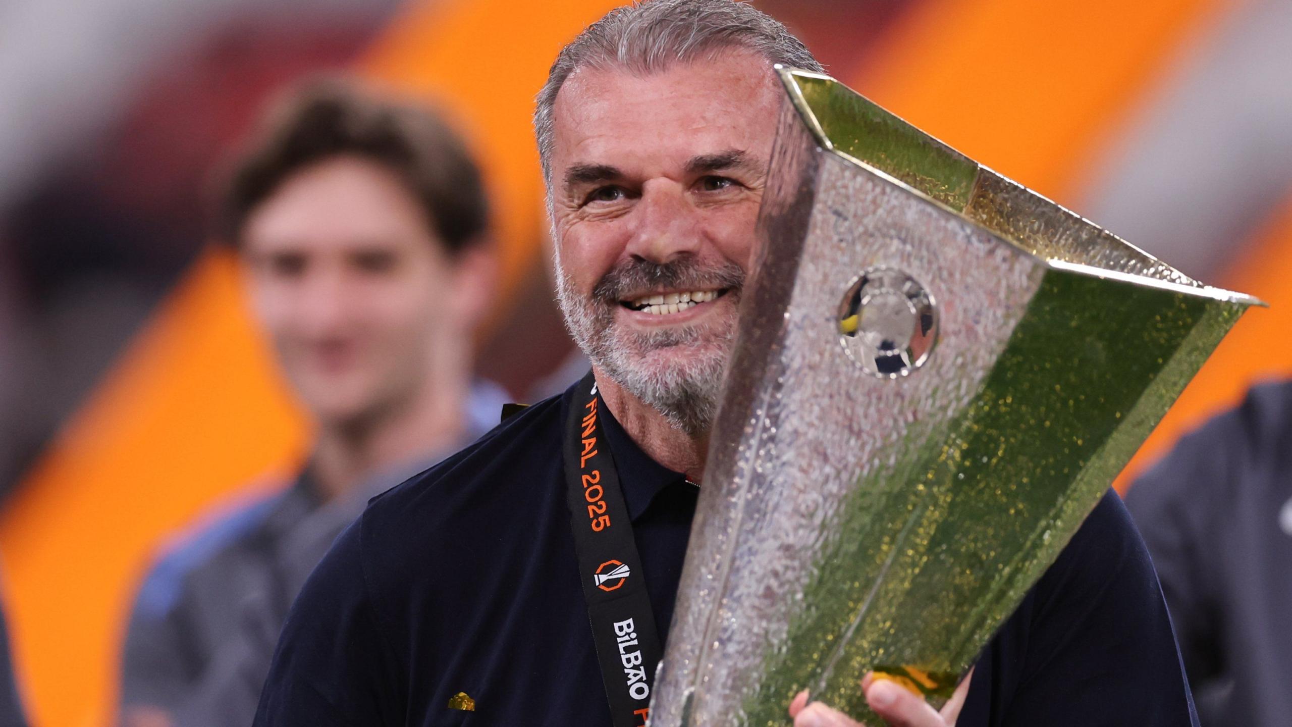 A picture of former Tottenham Hotspur manager Ange Postecoglou holding the Europa League trophy.